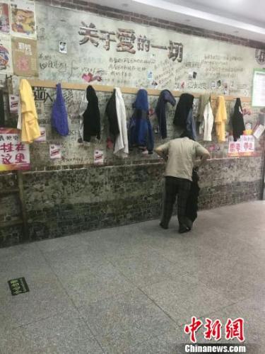 市民在“爱心墙”旁挑选衣物 王天译 摄
