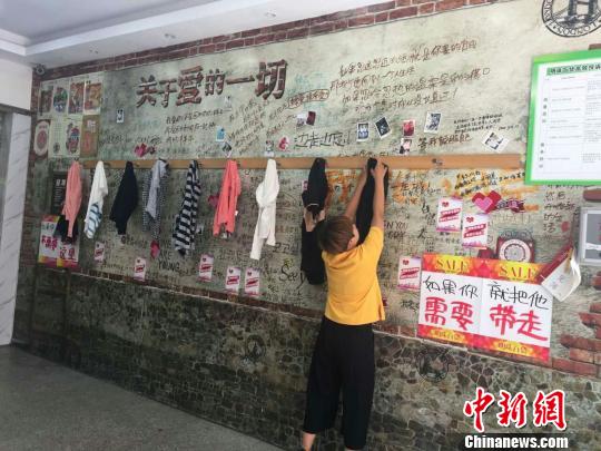 市民将不需要的衣物挂在“爱心墙”上 王天译 摄